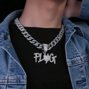Detail van hiphop Cubaanse schakelketting met ijzige PLUG-letterhanger en strass