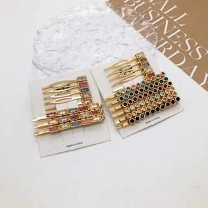 Colorful rhinestone hair clip set with gold alloy base on a white display card