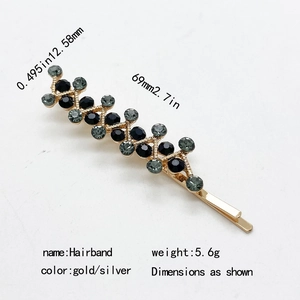 Sparkling gold metal hair clip with black and grey rhinestones in a wavy pattern design
