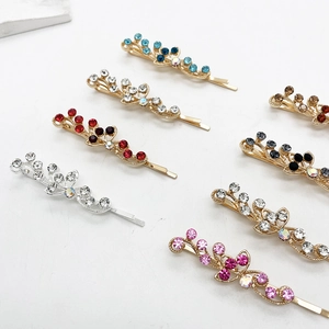 Barrettes élégantes en or et argent avec strass colorés sur un fond blanc pur