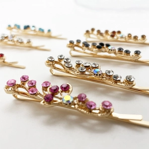 Barrettes à cheveux colorées en strass avec base en alliage doré en disposition élégante