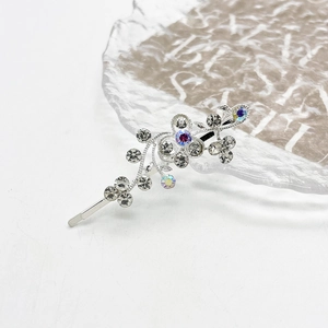 Gedetailleerde close-up van een zilveren haarspeld met glinsterende strass en bloemen