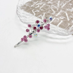 Detail van zilveren bloemen haarspeld met roze en iriserende strass steentjes