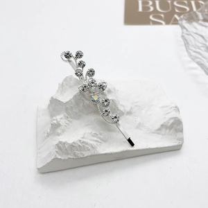Gros plan d'une barrette à strass étincelants sur un support en plâtre blanc