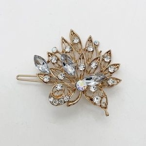 Detailed macro view of a gold leaf hair clip featuring sparkling rhinestones and crystals