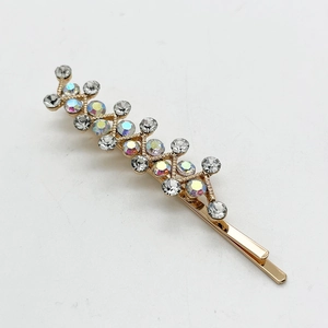 Detailed close-up of golden hair clip with shimmering rhinestones in a vine design