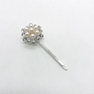 Detalle del pasador plateado con perlas blancas y diamantes de imitación brillantes