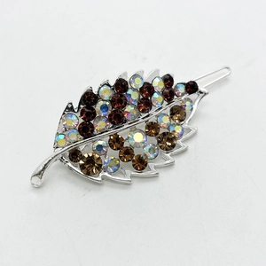 Detail of leaf-shaped hair clip with brown and iridescent AB rhinestones on silver metal
