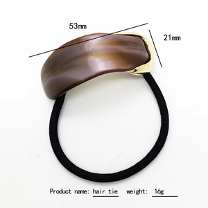 Elegant tortoise shell acetate hair tie with golden metal accent and black elastic band