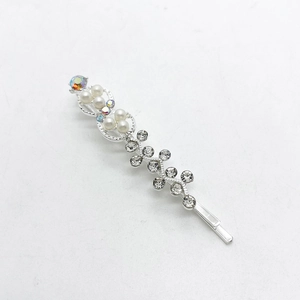 Detalle de un pasador de pelo plateado con perlas blancas y cristales brillantes