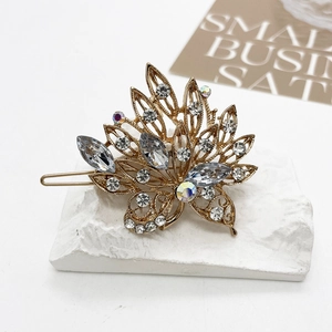 Detailed close-up of golden leaf hair clip with marquise crystals and sparkling rhinestones