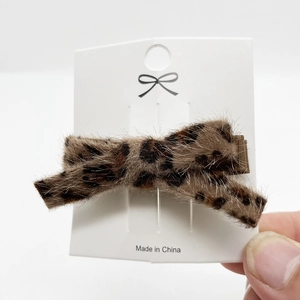 Dettaglio del fermaglio per capelli a fiocco con stampa leopardata in soffice ecopelliccia
