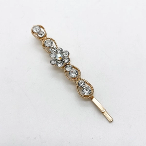 Detalle de una horquilla dorada elegante con motivo de flor y brillantes diamantes de imitación
