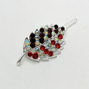 Macro shot of silver leaf hair clip with dark red and multi-color rhinestones