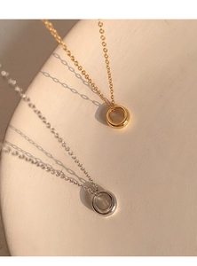 Detailed view of minimalist gold and silver geometric round pendants on fine metal chains