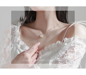 Détail d'un collier en argent 925 avec nacre et pendentif serrure dorée sur un mannequin