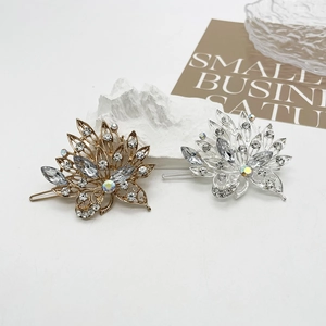 Detailed macro view of gold and silver leaf hair clips with sparkling crystals