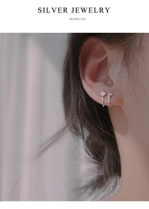 Detailed close-up of S925 sterling silver ear cuffs and cubic zirconia studs on ear