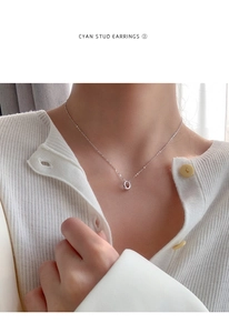 Close-up of minimalist silver circular pendant necklace worn on female neck