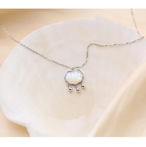 Détail du collier de nacre en forme de serrure ruyi dans un coquillage blanc décoratif