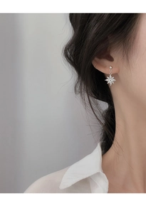 Détail de puce d'oreille flocon argenté sertie de zircons marquise sur un mannequin