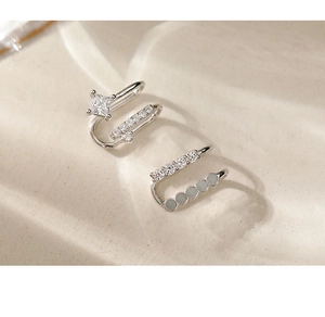 Close-up of double-layer silver ear cuffs with square zirconia and pearl details