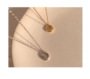 Minimalist gold and silver circular pendants on elegant white textured displays