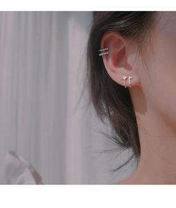 Close-up of asymmetrical double-layer silver ear cuffs with sparkling zircon stones