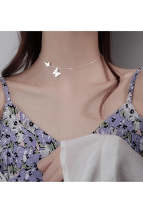 Close-up of double butterfly pendant necklace on a model showing elegant neck details