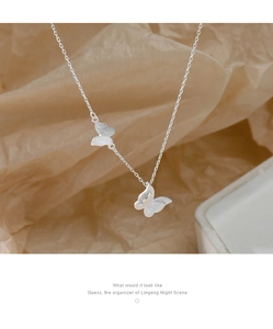Detail view of silver double butterfly pendant with a brushed matte finish on a thin chain