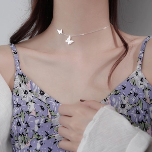 Minimalist silver butterfly necklace with delicate wings on a female model neck