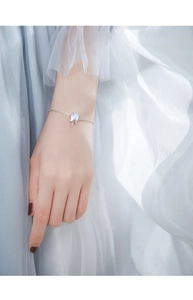 Vue rapprochée d'un bracelet licorne avec pendentif en opale bleue sur le poignet