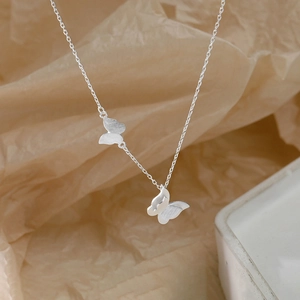 Elegant silver double butterfly necklace with brushed texture on minimalist chain link