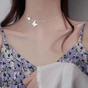 Minimalist silver butterfly pendant necklace for women shown on a fashion model neckline