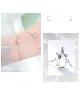 Détail macro du bracelet licorne en argent avec perle de lune et breloque arc-en-ciel