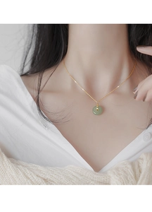 Détail d'un collier vintage en argent s925 plaqué or avec pendentif donut en jade vert