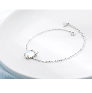 Détail du bracelet licorne argentée avec pierre de lune sur une assiette en céramique