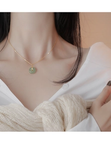 Gros plan d'un collier vintage en argent s925 avec pendentif en jade vert sur un mannequin