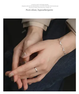Détail d'un bracelet vague en argent 925 avec zircons scintillants sur un modèle