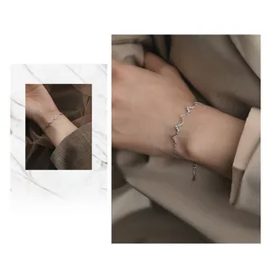 Vue détaillée du bracelet vague en argent S925 avec breloques cœur et zircons blancs