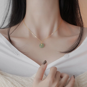 Élégant collier en argent s925 plaqué or avec pendentif rond en jade vert sur un modèle