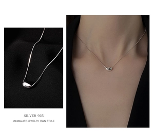 Macro detail of S925 sterling silver bean pendant necklace with minimalist jewelry design