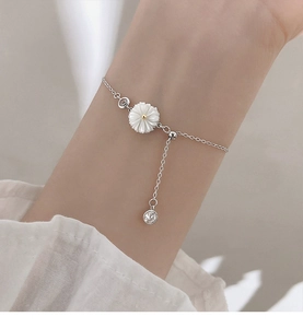 Detailed close-up of a sterling silver daisy bracelet with adjustable slider and zircon charm