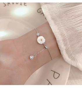 Close-up of sterling silver daisy bracelet with white shell flower and zircon stones