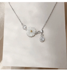 Macro view of sterling silver daisy necklace with shell petals and sparkling zircon detail