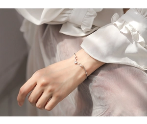 Detailed view of a silver reindeer antler bracelet with a sparkling zircon on a woman's wrist