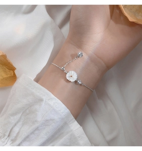 Close-up of S925 silver daisy bracelet with shell petals and zircon accents on a wrist