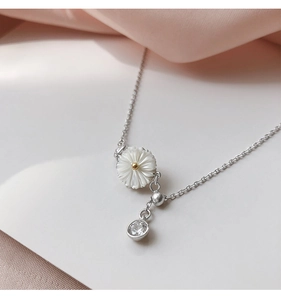 Detailed close-up of 925 sterling silver daisy bracelet with shell petals and zircon charm