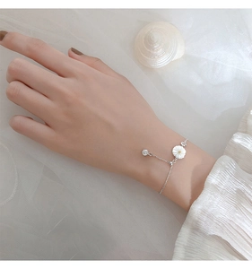Detailed shot of silver daisy bracelet with shell accents and adjustable slider clasp