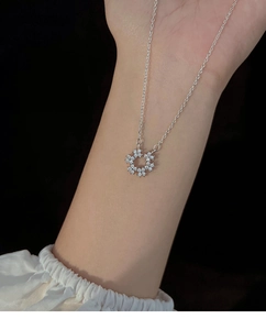 Détail macro du collier pendentif couronne florale argentée avec zircons brillants